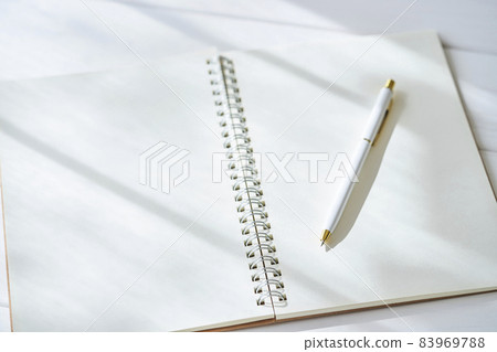 Open plain ring notebook and ballpoint pen 83969788
