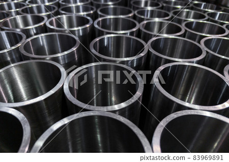 dark industrial background with cnc machined shiny steel pipes - selective focus and lens blur tech 83969891