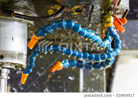 blue plastic water and air flexible hoses of milling machine covered by oil and steel chips 83969917
