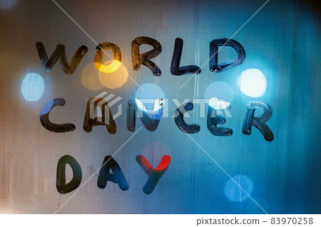 the words world cancer day handwritten on night wet glass - close-up with background blur 83970258