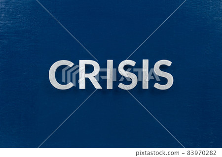 the word crisis laid with silver metal letters on blue surface for stock market background the word crisis laid with silver metal letters on blue surface for stock market background 83970282