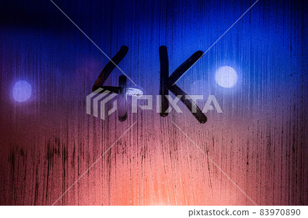 The word 4k handwritten on wet glass with blurred night lights in background 83970890