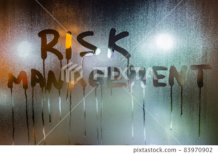 the word risk management handwritten on night wet window glass 83970902