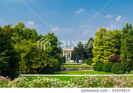 Arch of Peace gate and green trees, grass lawn in park, Milan, Italy 83974825