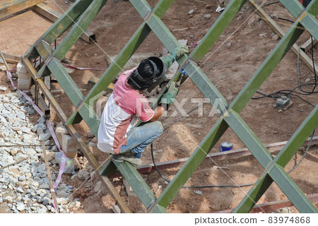 SELANGOR, MALAYSIA -DECEMBER 09, 2015: Welder wearing protective mask welding metal at the construction site.  83974868