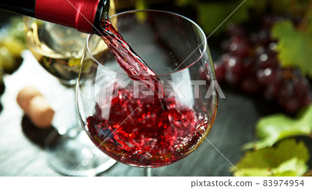 Macro shot of pouring red wine into glass. Macro shot of pouring red wine into glass. 83974954