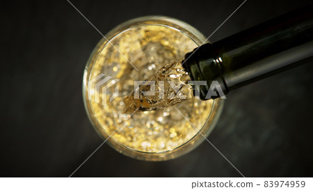 Top shot of pouring champagne wine into glass. Top shot of pouring champagne wine into glass. 83974959