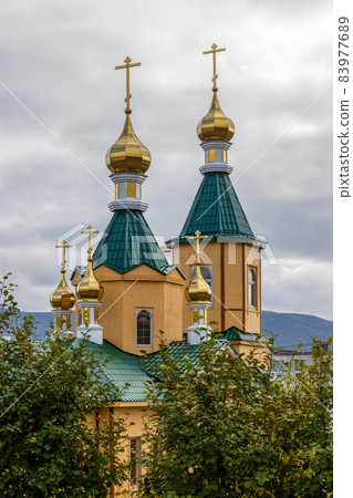 View of a beautiful Orthodox church with gilded domes and crosses. View of a beautiful Orthodox church with gilded domes and crosses. 83977689