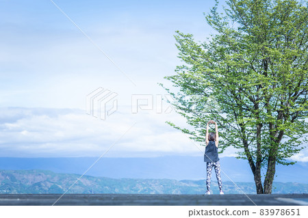 A woman in sportswear (stretching) in a superb view A woman in sportswear (stretching) in a superb view 83978651