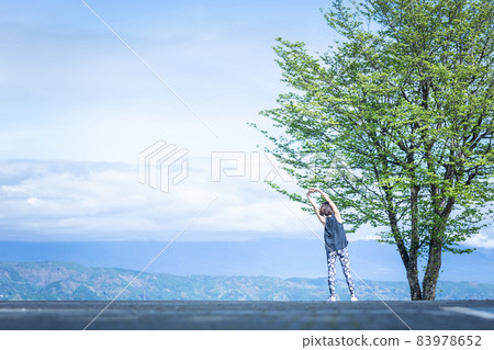 A woman in sportswear (stretching) in a superb view A woman in sportswear (stretching) in a superb view 83978652