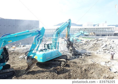 Building demolition work site with large heavy machinery demolished 83979205
