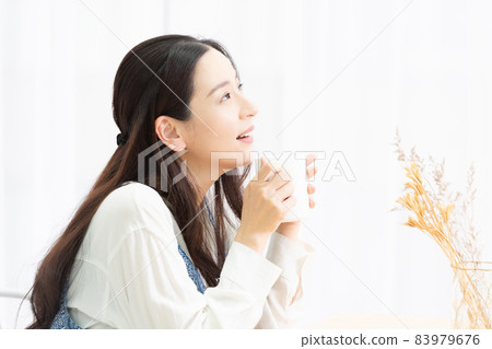 Housewife thinking while drinking coffee in the living room 83979676