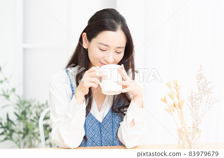 Housewife thinking while drinking coffee in the living room 83979679