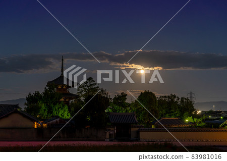 Ikaruga Town, Nara Prefecture, a harvest moon rising from the other side of the three-storied pagoda of Hokiji Temple, a World Heritage Site 83981016