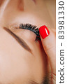 Eyelash Extension Procedure. Woman Eye with Long Eyelashes. Close up, selective focus. 83981330
