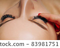 Eyelash Extension Procedure. Woman Eye with Long Eyelashes. Close up, selective focus. 83981751