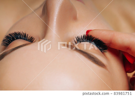 Eyelash Extension Procedure. Woman Eye with Long Eyelashes. Close up, selective focus. Eyelash Extension Procedure. Woman Eye with Long Eyelashes. Close up, selective focus. 83981751