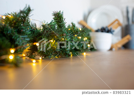 light bulbs in coniferous branches on kitchen table. christmas atmosphere.home decor for celebration light bulbs in coniferous branches on kitchen table. christmas atmosphere.home decor for celebration 83983321