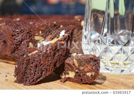 Chocolate cake brownie with nuts on wood plate Chocolate cake brownie with nuts on wood plate 83983917