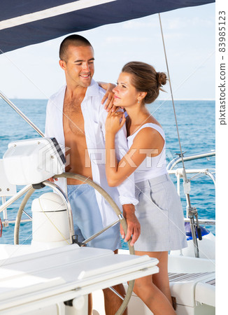 Man and woman steering pleasure yacht 83985123