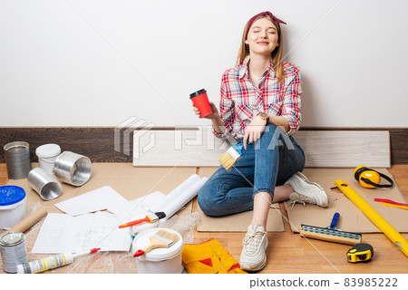Dreamy beautiful girl painter sitting on floor 83985222