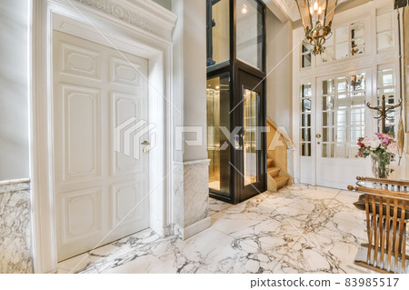 Elegant entrance hall with black glass lift Elegant entrance hall with black glass lift 83985517