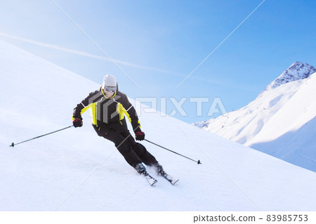 Alpine skier on piste running downhill Alpine skier on piste running downhill 83985753