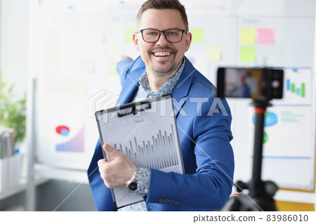 Young smiling businessman blogger conducts business development training Young smiling businessman blogger conducts business development training 83986010