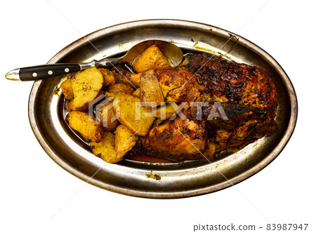 Portion of roasted chicken with potatoes on metal dish 83987947