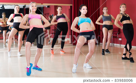 Women dancing zumba movement in dance class Women dancing zumba movement in dance class 83988006