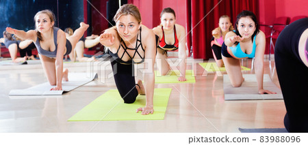 Women exercising yoga poses in fitness center 83988096