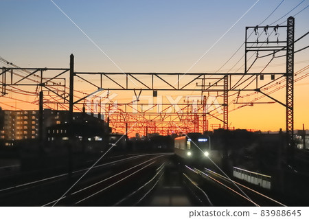 Running train and sunset sky seen from Kameari station platform 83988645