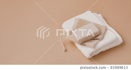 A bar of natural handmade soap lies on a soft white towel. Health beauty natural products concept. Organic natural cosmetics A bar of natural handmade soap lies on a soft white towel. Health beauty natural products concept. Organic natural cosmetics 83989613