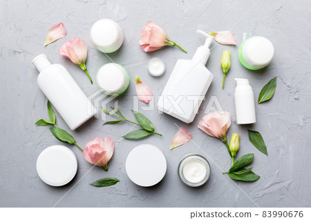 Composition with cosmetic products and beautiful roses on cement background. Flat lay 83990676