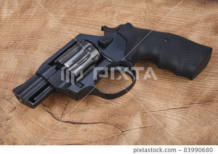 Cocked and locked revolver on wooden table 83990680