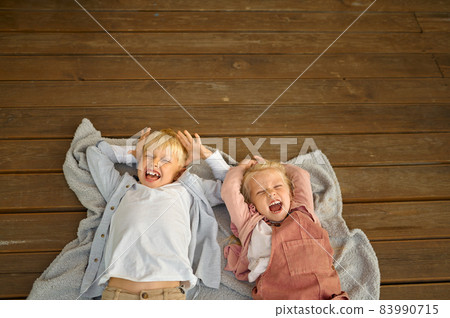 Funny children lying on terrace floor in trailer 83990715