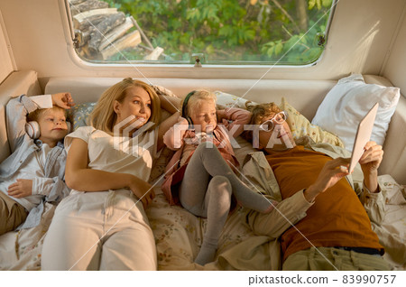 Cheerful family lying in bed in motorhome, camping Cheerful family lying in bed in motorhome, camping 83990757