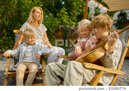 Father plays guitar for his family at the trailer Father plays guitar for his family at the trailer 83990774