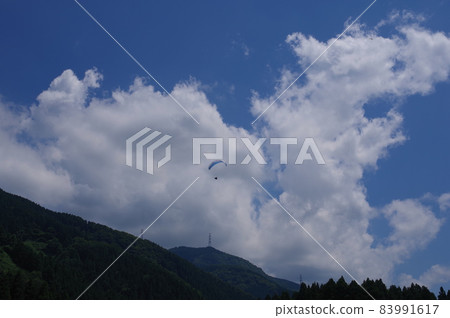 A paraglider flying over the Shishiku Highland A paraglider flying over the Shishiku Highland 83991617