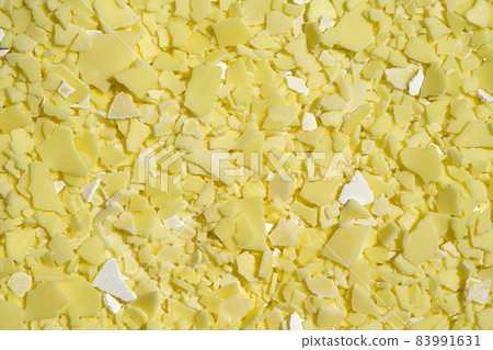 Closeup chemical ingredient on laboratory table (Top View). Sodium sulfide flakes, a yellow appearance owing to the presence of polysulfides. Science background. 83991631