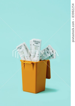 used covid-19 rapid test devices in the dustbin 83992254