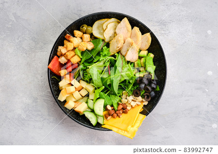 Top view of bowl with salad mix and various snacks 83992747