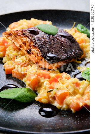 Closeup view of fried salmon steak served with bulgur and sweet potato 83992776