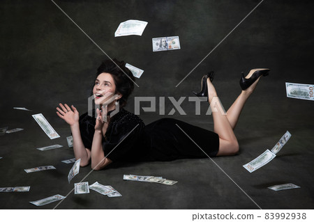 Creative portrait of young adorable woman in image of medieval royal person in black dress isolated on dark vintage background. Creative portrait of young adorable woman in image of medieval royal person in black dress isolated on dark vintage background. 83992938