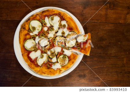 Italian pizza with zucchini, eggplant and green olives Italian pizza with zucchini, eggplant and green olives 83993410