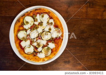 Italian pizza with zucchini, eggplant and green olives Italian pizza with zucchini, eggplant and green olives 83993411
