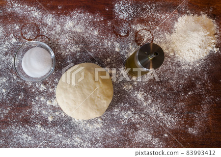 Dough for pizza over a wooden table Dough for pizza over a wooden table 83993412