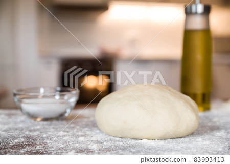 Closeup of dough for pizza over a wooden table Closeup of dough for pizza over a wooden table 83993413