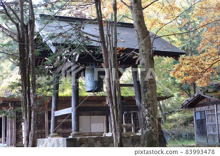 Scenery of an old folk house with a bell tower, a hut and a thatched roof in a forest of trees of various colors and types Scenery of an old folk house with a bell tower, a hut and a thatched roof in a forest of trees of various colors and types 83993478