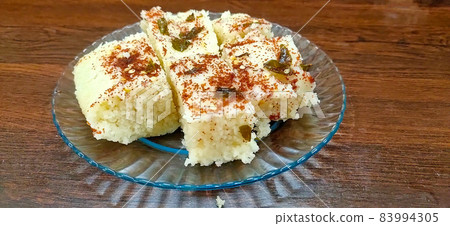 Indian gujarati Traditional Street Food Khaman Dhokla snack made from chick pea flour and rava Served With sev and Chilli 83994305